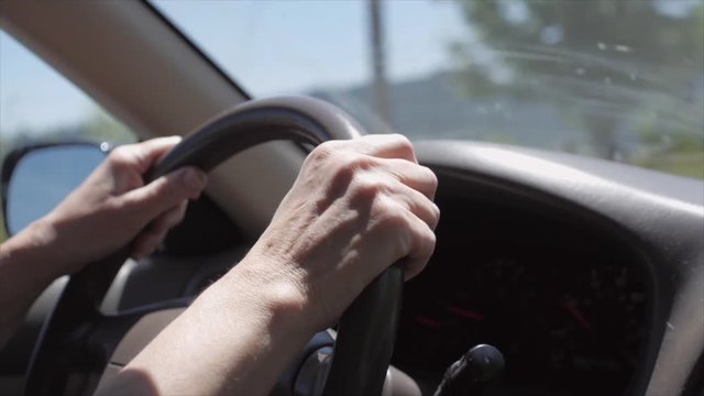 Woman driving a car guiding steering wheel