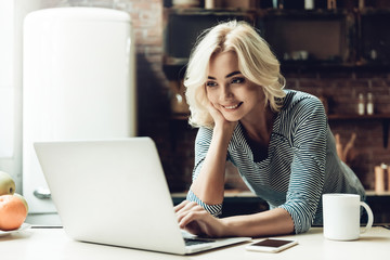 Young Smiling Beautiful Woman Using Laptop at Home