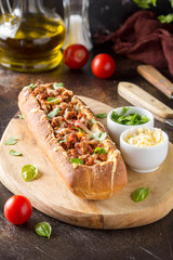 Baguette stuffed with bolognese ragout of minced beef, tomatoes and cheese. A delicious Italian lunch, tasty snacks, homemade sandwich