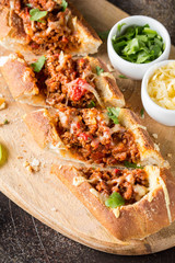 Baguette stuffed with bolognese ragout of minced beef, tomatoes and cheese. A delicious Italian lunch, tasty snacks, homemade sandwich