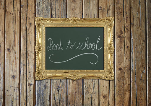 Old antique gold frame on textured wooden wall