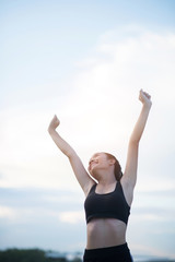 Happy smiling athletic woman with arms outstretched