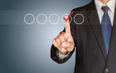 Businessman hand checking the checklist boxes on blue background