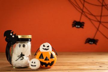 Halloween crafts, orange pumpkin, ghost and spide on wooden table and orange background with copy space for text. halloween concept.