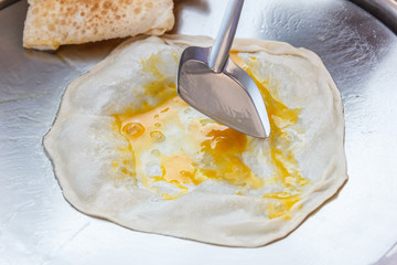 Chef making roti and egg.
