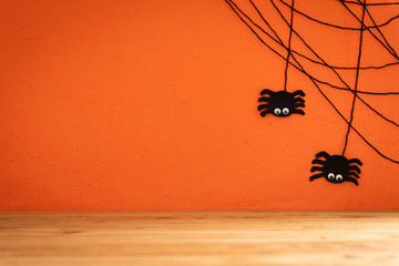 Halloween crafts, spide and cobweb on orange background with copy space for text on wooden table. halloween concept.