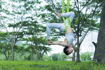 Young asian woman practicing yoga together, Fitness, stretching practice, woman doing Advanced yoga pose in the nature; Wellness concept.