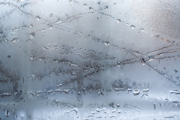 Melting ice patterns on window glass.