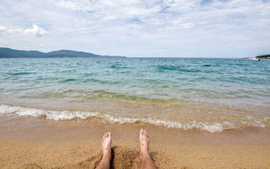 Sitting man on shore by the sea.