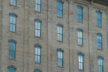 Old architecture brick apartment building exterior establishing shot. Uniform window design and pattern on building facade. Day time outside stock photo
