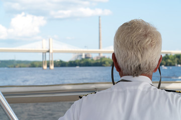 Over the shoulder POV view of a boat captain sailing down a river. Charting navigation path under...