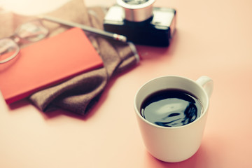 Back coffee flat table with blur camera notebook and travel stuff of sunlight shining with soft focus, vintage style color effect.