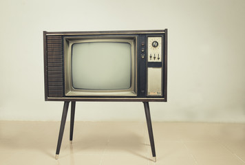 Retro tv with wood case on stand at wall background, vintage old TV with stand on the floor in the room.
