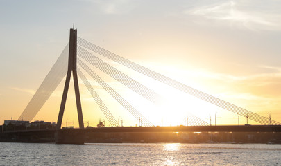Fototapeta na wymiar Transport bridge across the river at sunset
