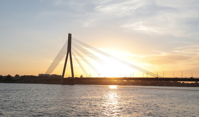 Fototapeta na wymiar Transport bridge across the river at sunset