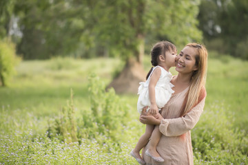 Mother and little daughter playing together in a park
