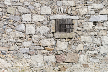 Natursteinmauer mit Fensterladen