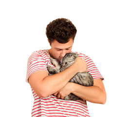 Obraz premium A cat and a man, a portrait of a happy cat with close eyes and a young man, people playing with a kitten. The guy hugs his pet. emotional man isolated on white background