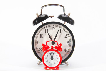 Red and black alarm clocks on a white background