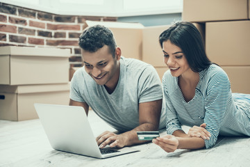 Young Smiling Couple Shopping Online on Laptop
