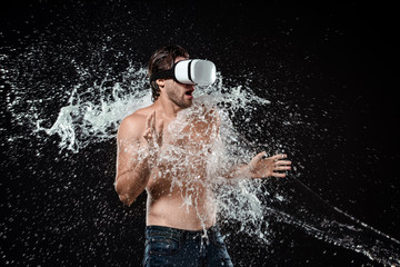 shirtless man in vr headset swilled with water isolated on black