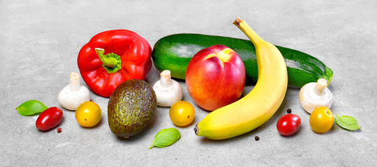 Delicious fresh fruits and vegetables on a concrete stone background. Top view with copy space.