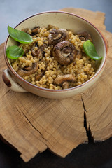 Bowl of pasta with roasted mushrooms in a rustic wooden setting, vertical shot