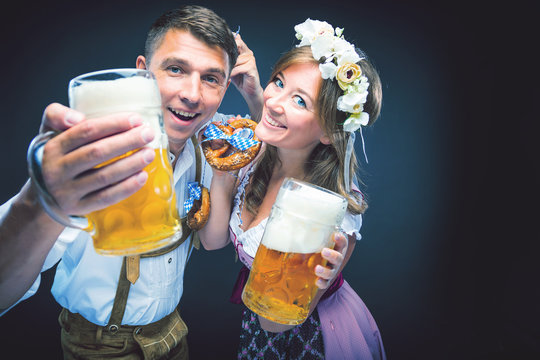 Oktoberfest, Frau und mann in Bayerischer Tracht mit Bier Krügen 