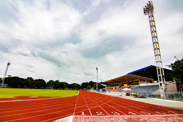 Obraz premium Red running track in the stadium.white line and Green lawn