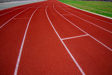 Red running track in the stadium.white line and Green lawn