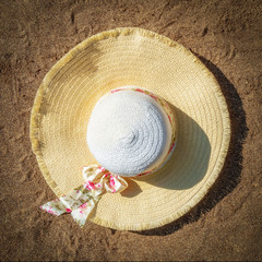 Fototapeta na wymiar Women's hat on the sandy beach. Top view.