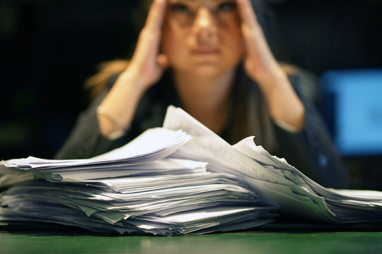 Close-up Of Office Worker Is Distressed With A Lot Of Paperwork In Front Of Her. A Lot Of Paper Work In Office. Yelling And Screaming For Bad Results. Businesswoman In Problems.