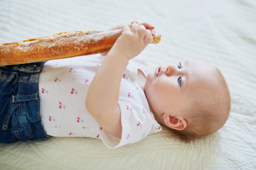 Six months old baby girl eating bread