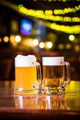 Glasses of light beer on a pub background.