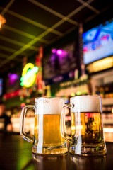 Fototapeta na wymiar Glasses of light beer on a pub background.