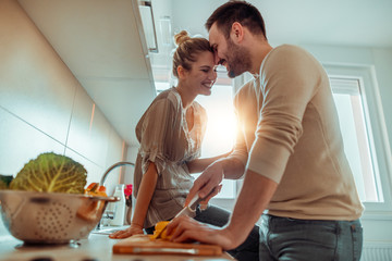 Young couple in kitchen preparing lunch
