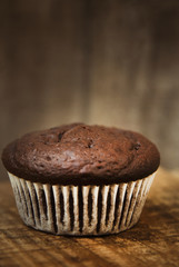 Chocolate muffins. Homemade chocolate muffins with spices on wooden background. Sweet dessert. Dark photo. Toned.