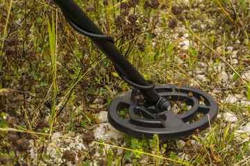 induction coil of metal detector close-up during ground scanning