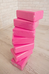 Plakat A stack of bricks for yoga pink color close-up. A stack of blocks for Pilates rose on a light background. Monophonic blocks for stretching