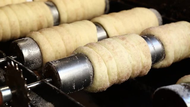 Close up chimney cake baking and rolling