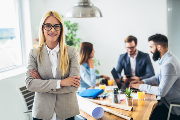Portrait of young businesswoman while colleague in background