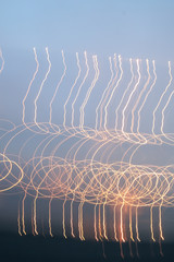 Orange light trails glowing against the sky in a looped C shape