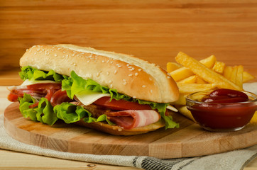Fresh submarine sandwich with cheese, bacon, tomatoes and lettuce