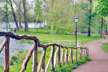 Fototapeta premium A fence made of untreated poles in the Park. Soft focus.