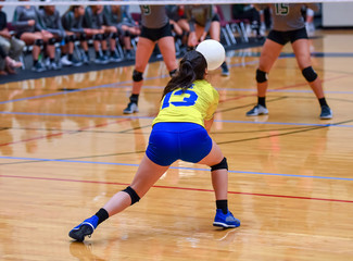 Girl Volleyball player and setter setting the ball for a spiker during a game