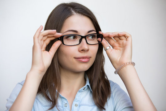 Eyeglasses for good vision, girl on white background with bad sight closeup