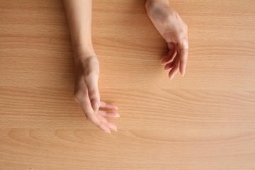 beautiful female hand on wood table background.