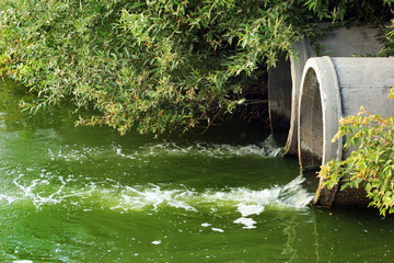 Discharge of sewage into a river - obrazy, fototapety, plakaty