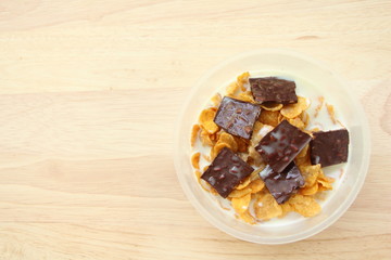 Cornflakes with chocolate and milk on brown wood background,Top view.