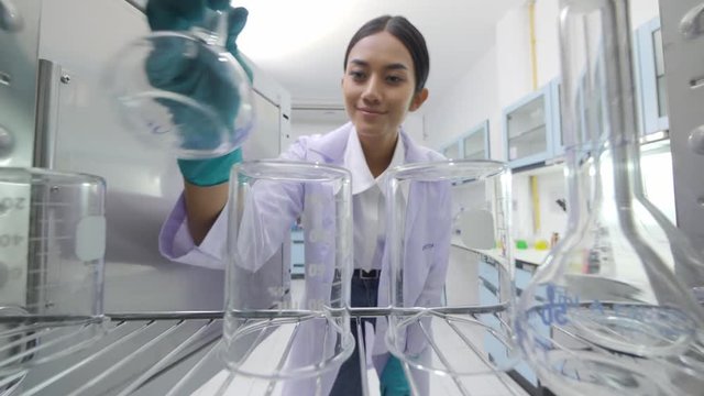 POV of Young asian female medical research scientists taking instruments from the sterilisation machine.